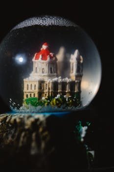 A glass snow globe featuring a detailed city skyline with falling snow inside