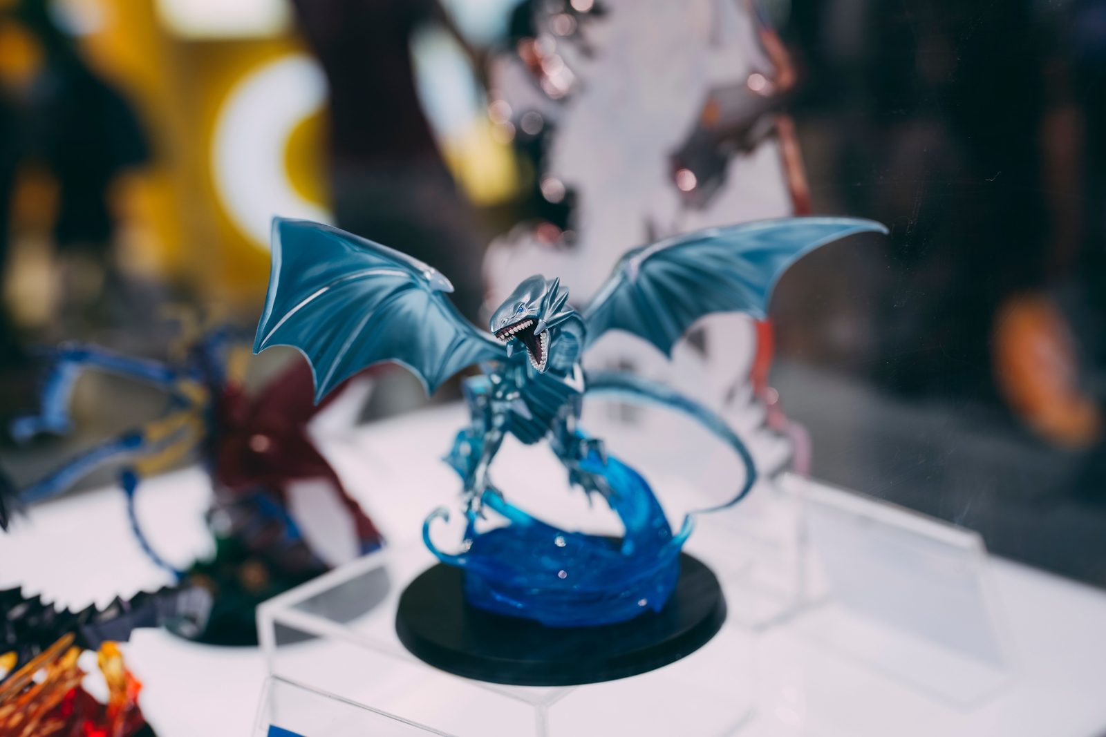 Close-up of a detailed blue dragon figurine displayed indoors at an exhibition.