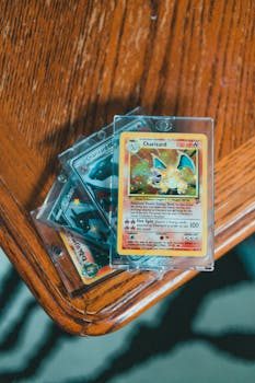 A PokÃ©mon card held up to a bright light showing a faint blue glow through the center