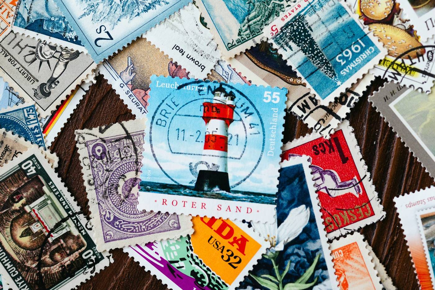 Collection of various postage stamps with lighthouse prominently displayed