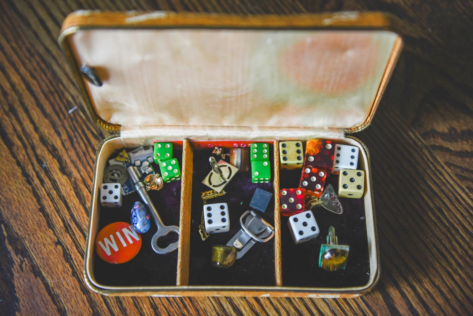 An open box filled with various dice and small trinkets