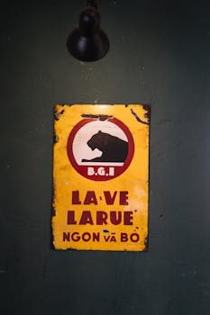 A faded vintage advertising sign mounted on a brick wall, showing authentic wear and patina