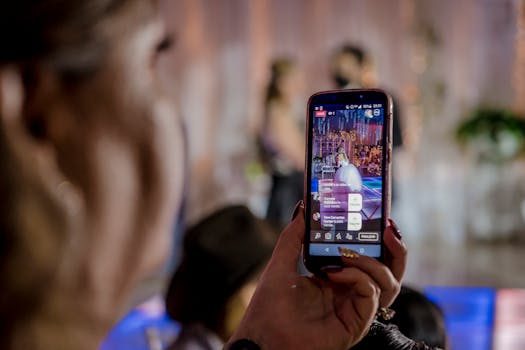 A person holding a smartphone showing a live auction on the WhatNot app